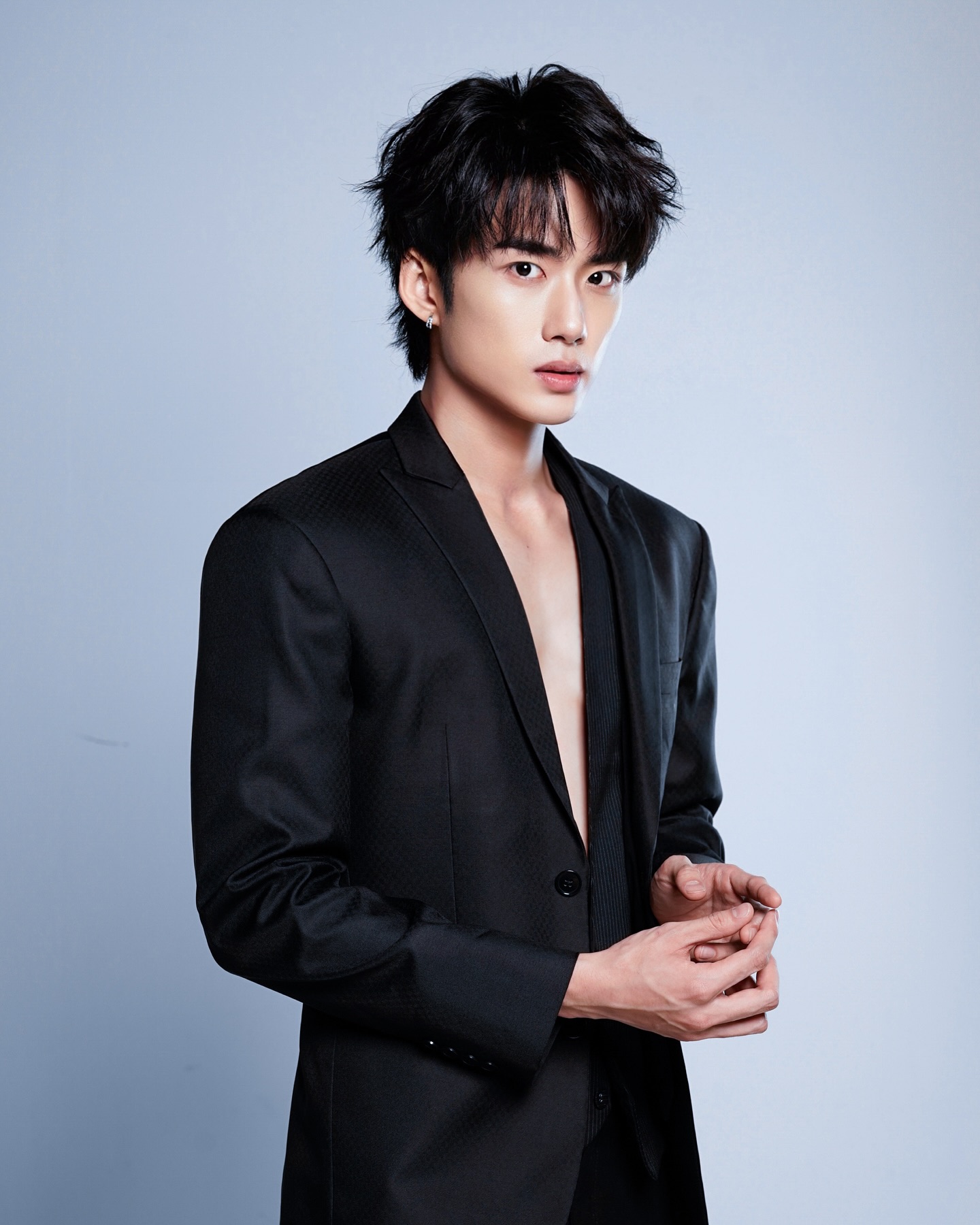 YANG YAN in a black blazer against a light backdrop
