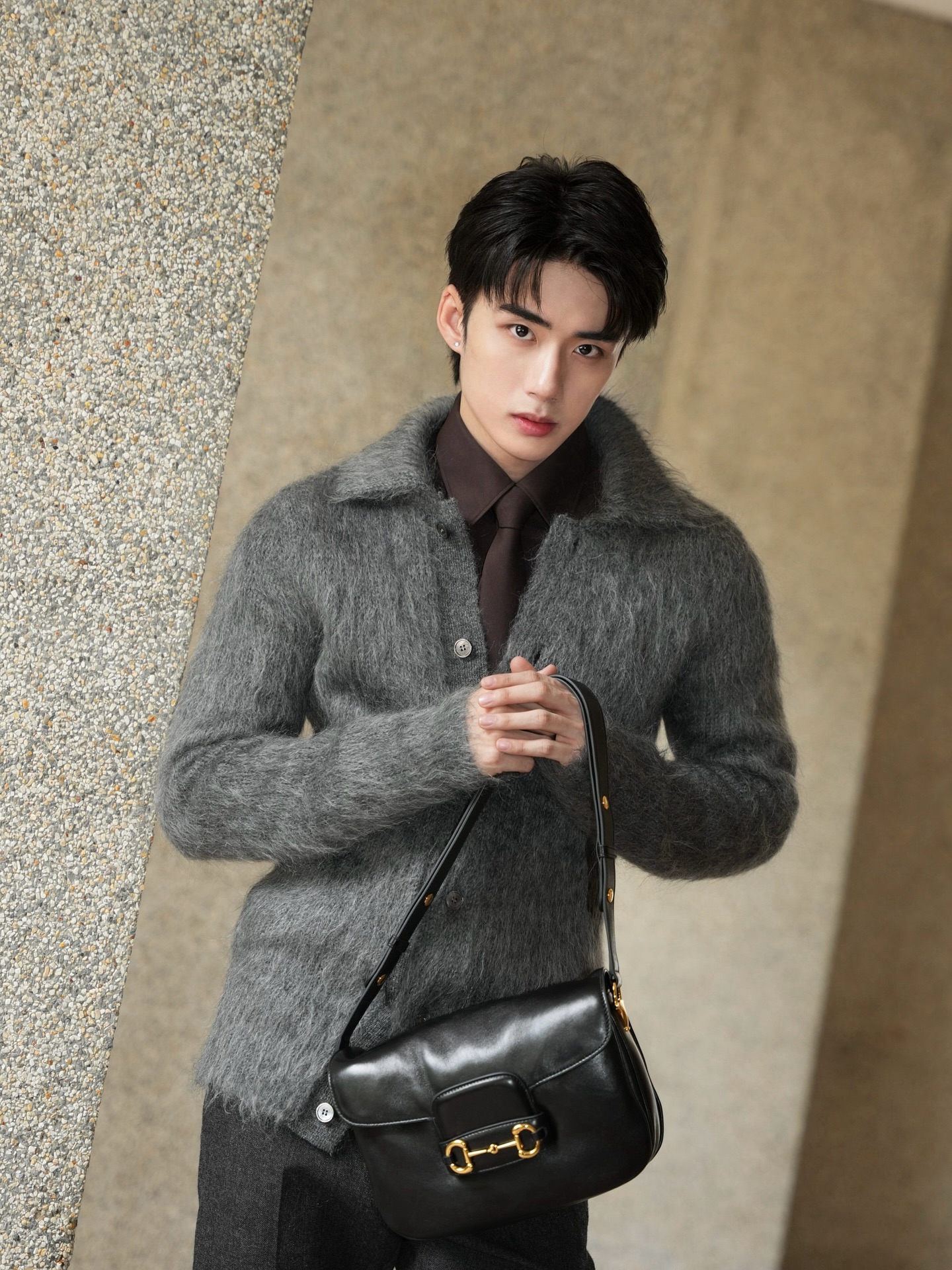YANG YAN in a grey mohair cardigan holding a black leather bag