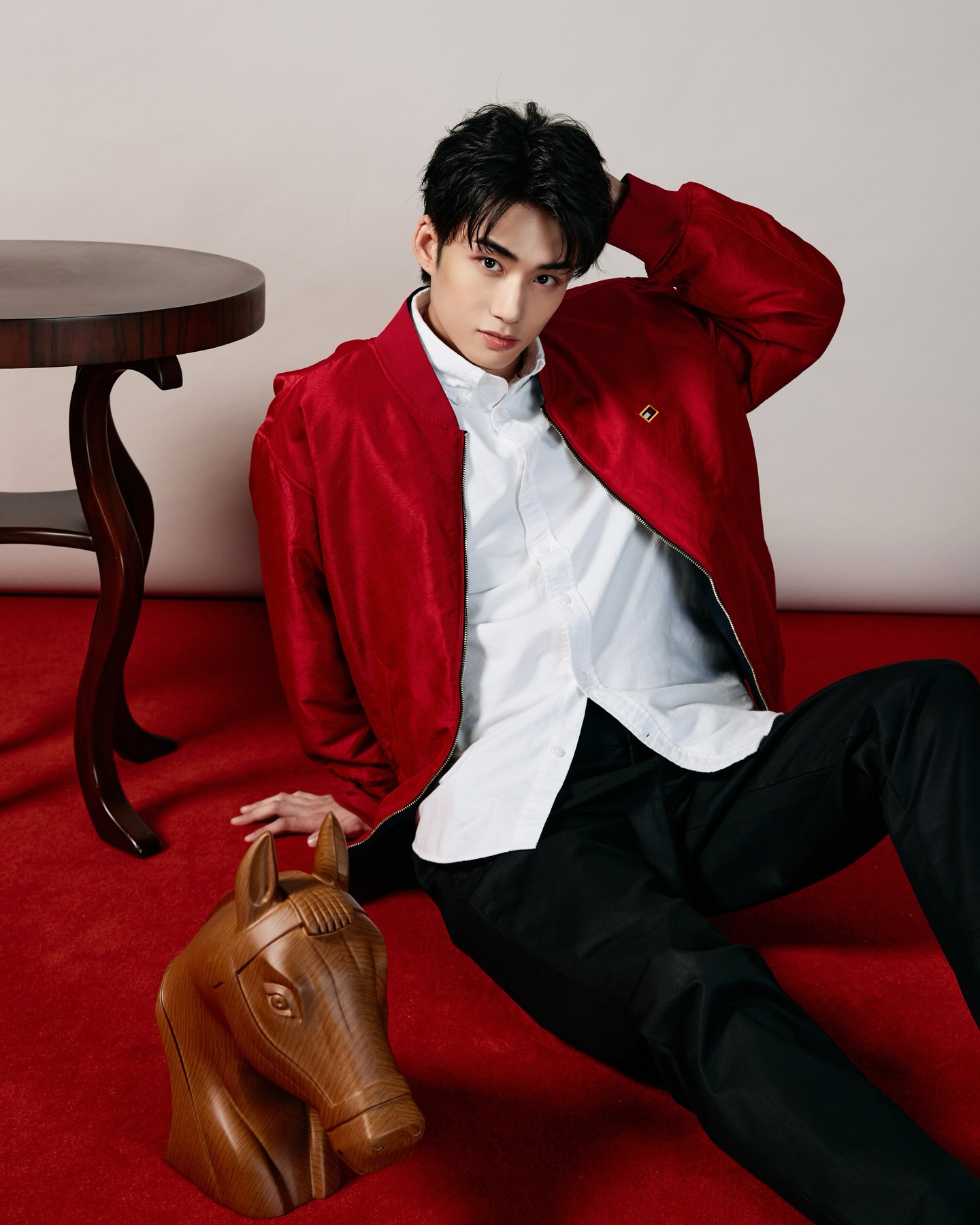 YANG YAN in a red bomber jacket and white shirt on a red carpet set