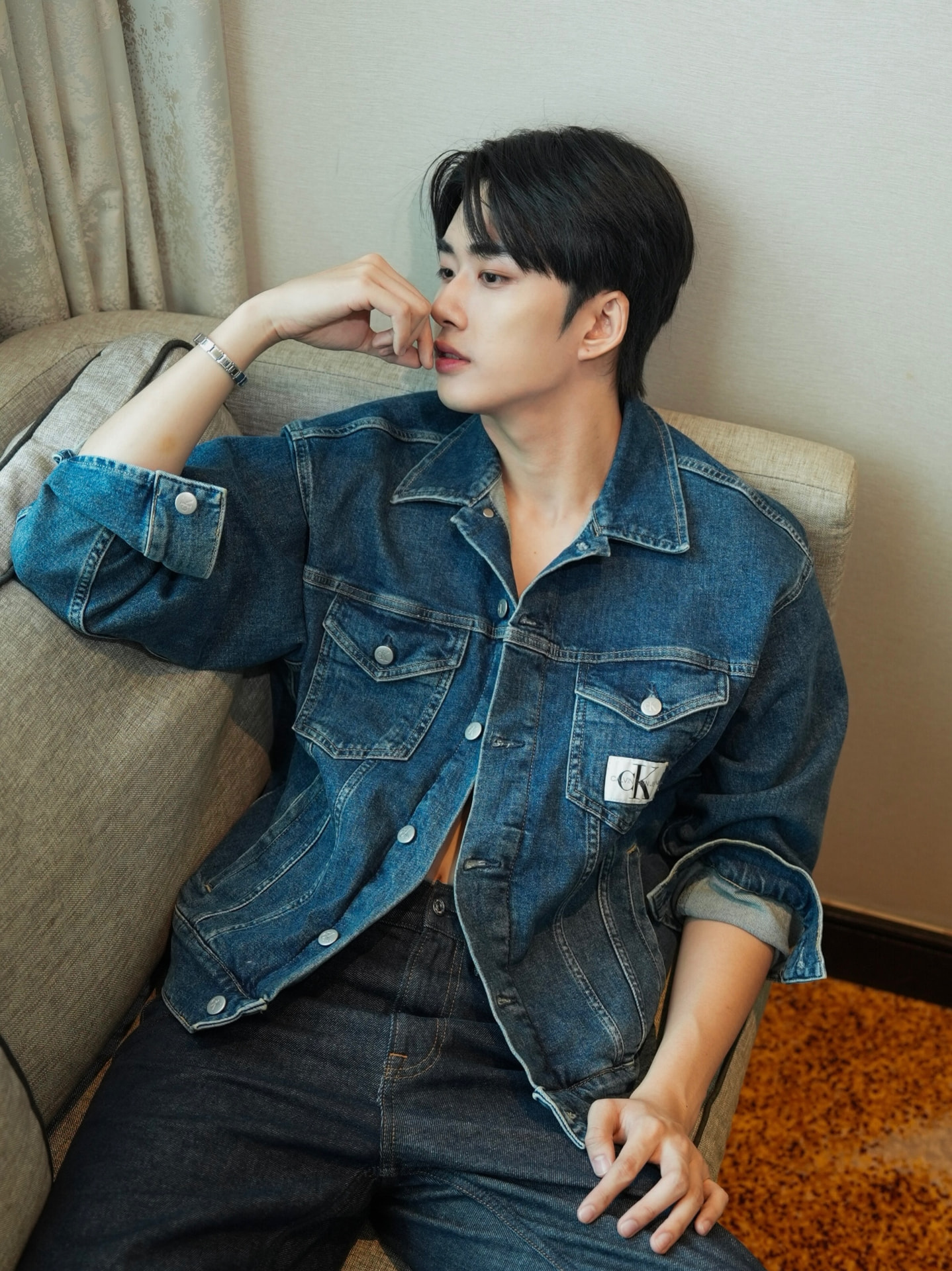 YANG YAN in a denim jacket seated on a sofa