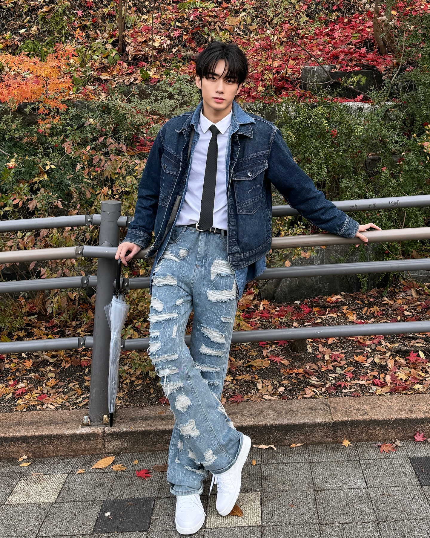 YANG YAN in a denim jacket and tie among autumn leaves